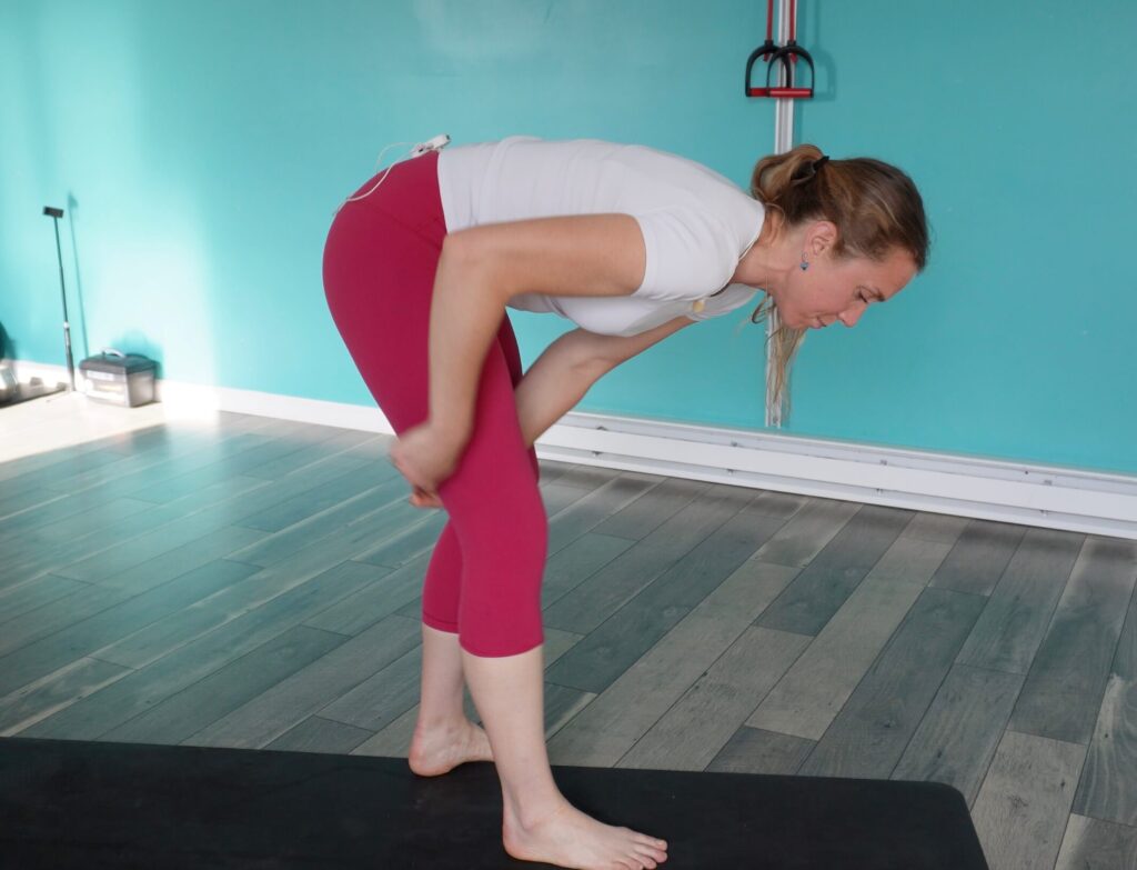 Dr. Chloe using the muscle scraper while standing through her hamstring